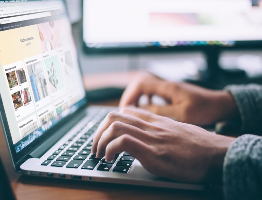 Person typing on a laptop with a website that shows results of a search.